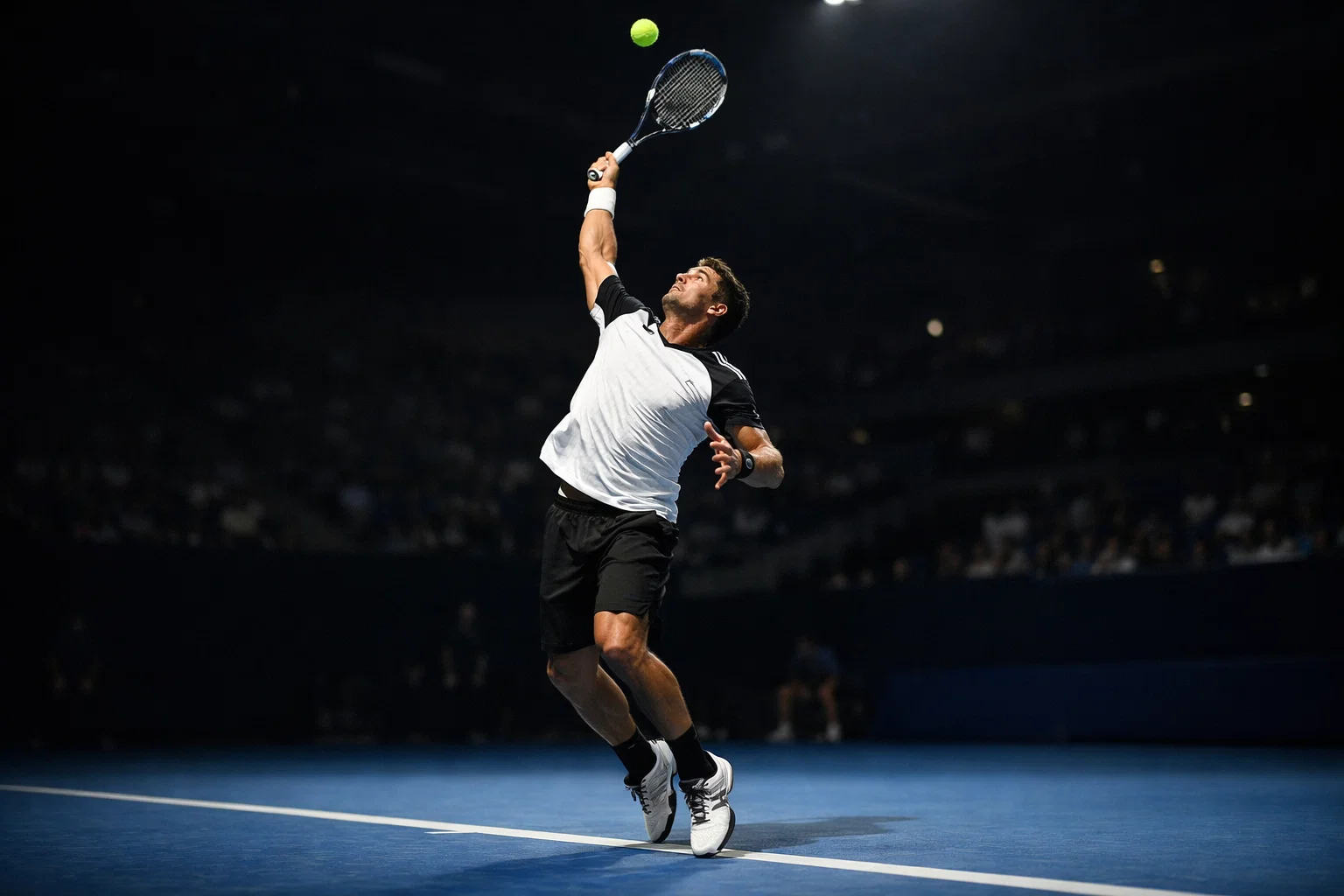 Tennista al servizio su un campo in cemento durante un torneo professionistico